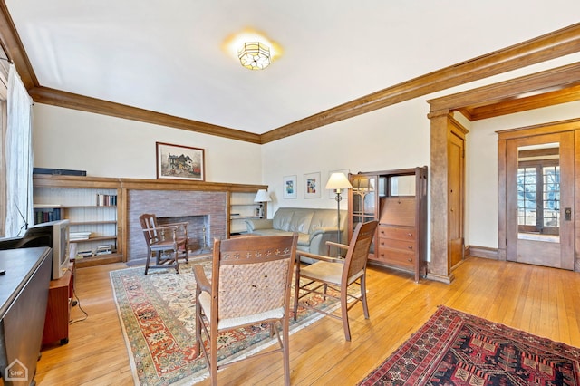 living room with ornamental molding, a fireplace, and light hardwood / wood-style flooring