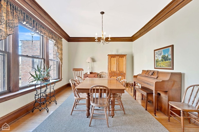 dining room featuring crown molding, an inviting chandelier, and light hardwood / wood-style flooring