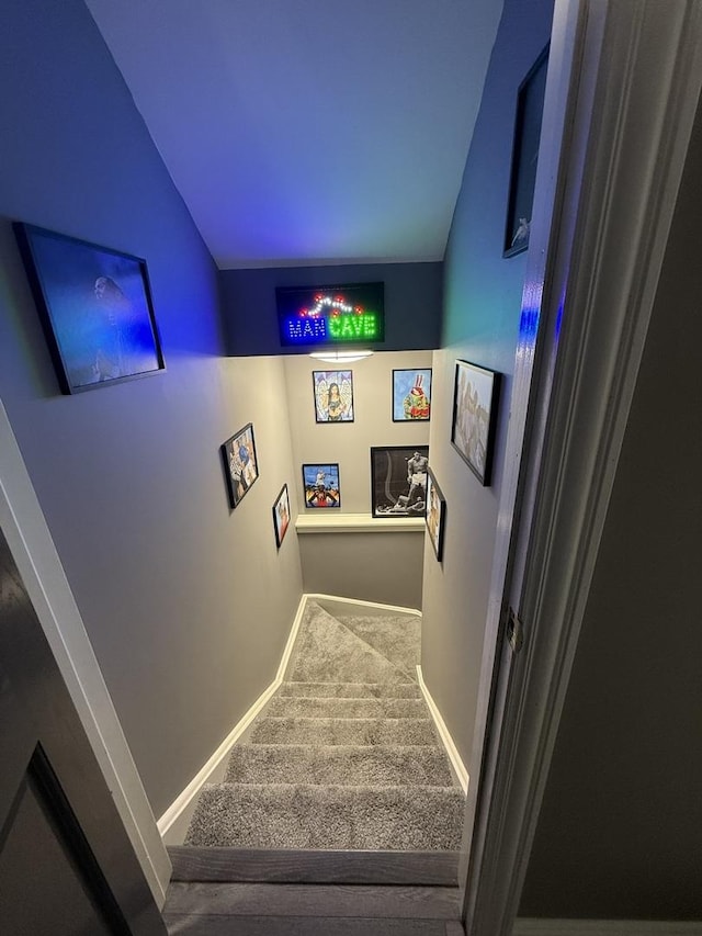 stairway with vaulted ceiling and carpet floors