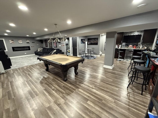 rec room with pool table, light wood-type flooring, beverage cooler, and bar area