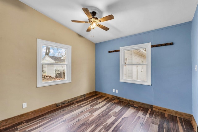 spare room featuring wood-type flooring, lofted ceiling, and ceiling fan