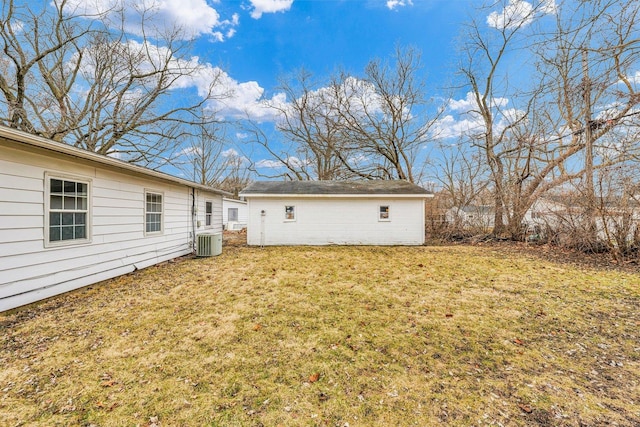 back of house with an outdoor structure, central AC unit, and a lawn