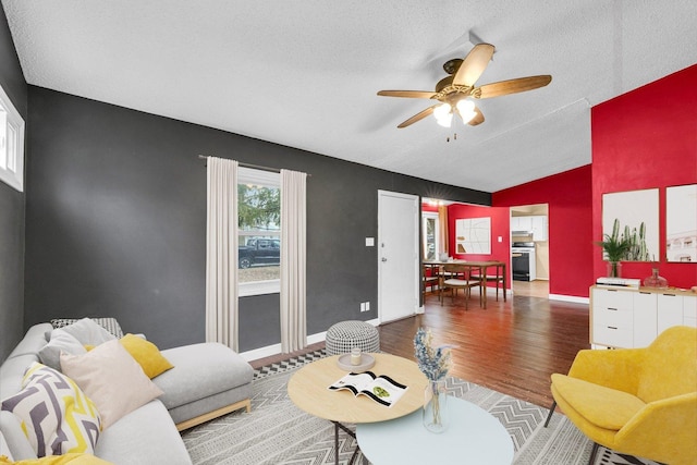 living room featuring dark hardwood / wood-style flooring, a textured ceiling, vaulted ceiling, and ceiling fan