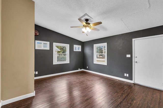 unfurnished room with plenty of natural light, lofted ceiling, and dark hardwood / wood-style flooring