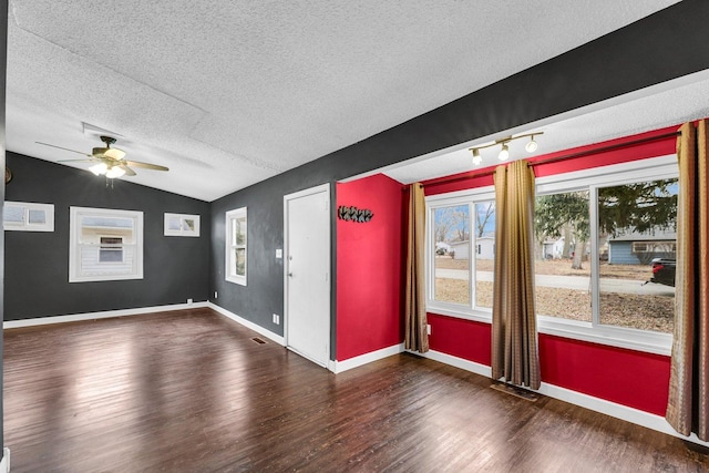 unfurnished room featuring ceiling fan, lofted ceiling, dark hardwood / wood-style floors, and a textured ceiling