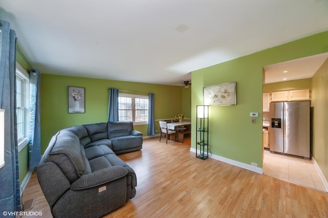 living room with ceiling fan and light hardwood / wood-style flooring