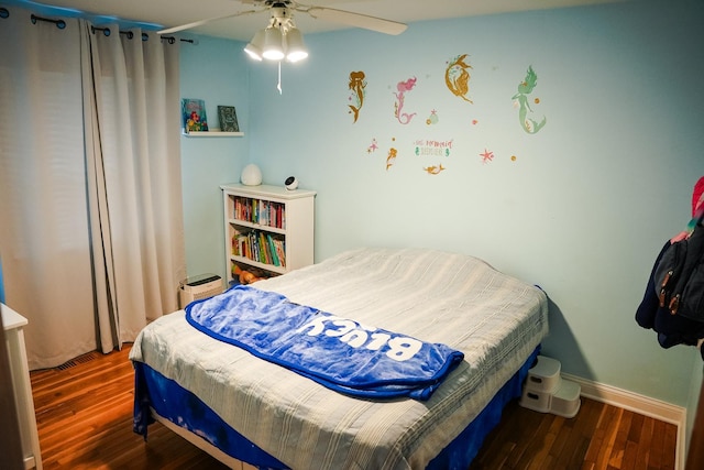 bedroom with dark wood-type flooring, ceiling fan, and baseboards