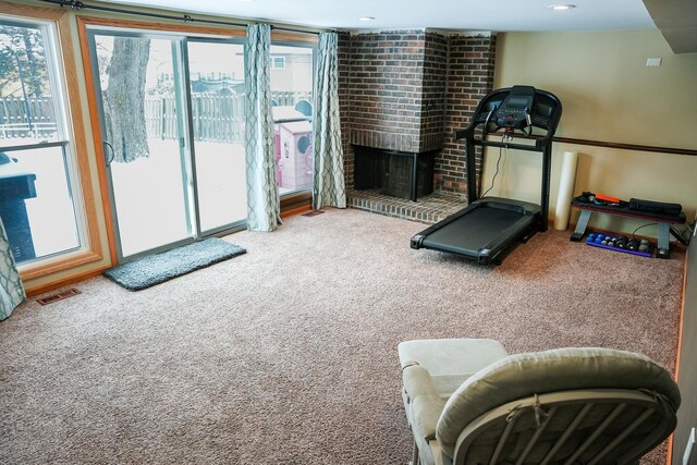 exercise area featuring a fireplace, visible vents, carpet flooring, and recessed lighting