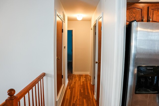 corridor with baseboards and dark wood-type flooring