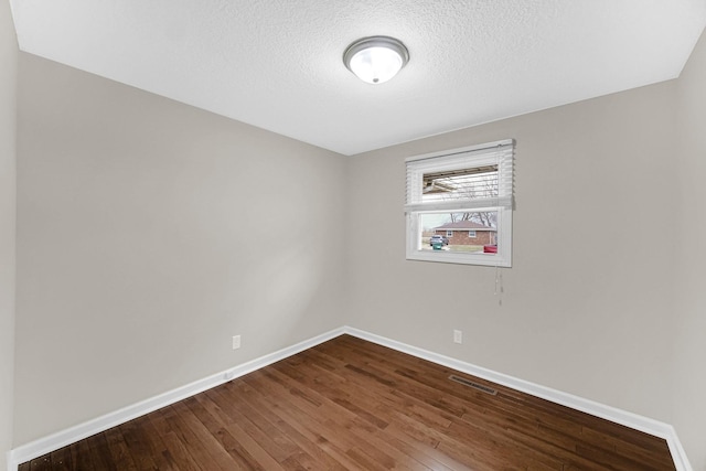 spare room with hardwood / wood-style flooring and a textured ceiling