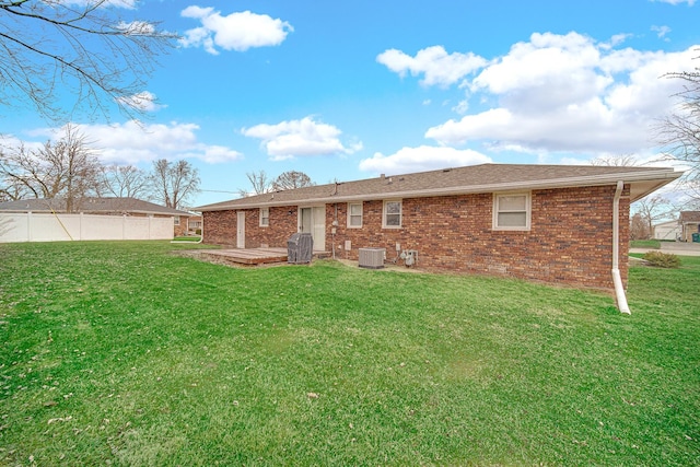 rear view of property with a patio, central air condition unit, and a lawn