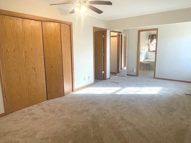 unfurnished bedroom featuring ceiling fan, ensuite bath, a closet, and light carpet