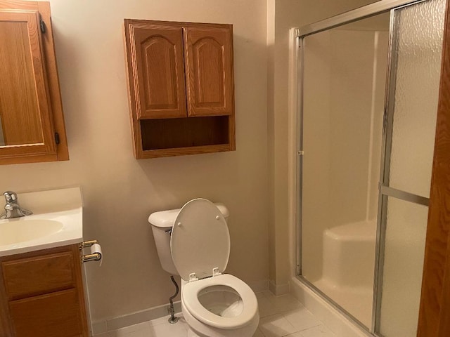 bathroom with tile patterned floors, vanity, toilet, and a shower with shower door