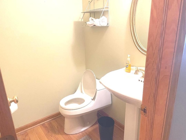 bathroom featuring wood-type flooring and toilet