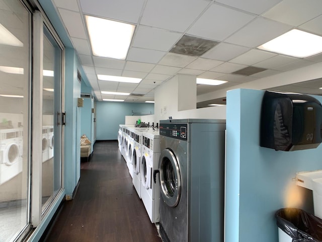 common laundry area with separate washer and dryer and dark wood-style flooring