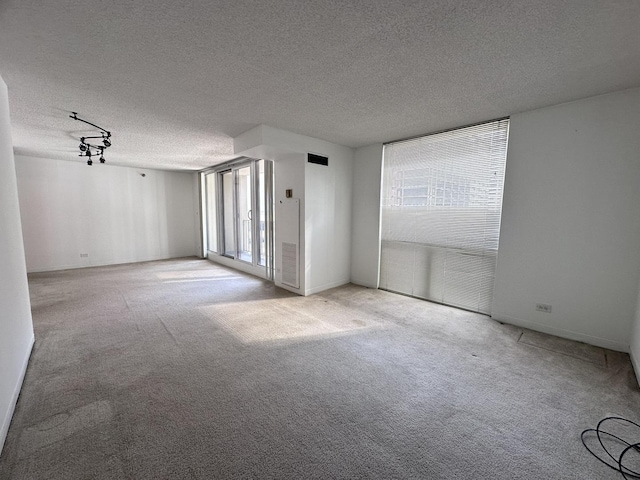 spare room with a textured ceiling and carpet floors