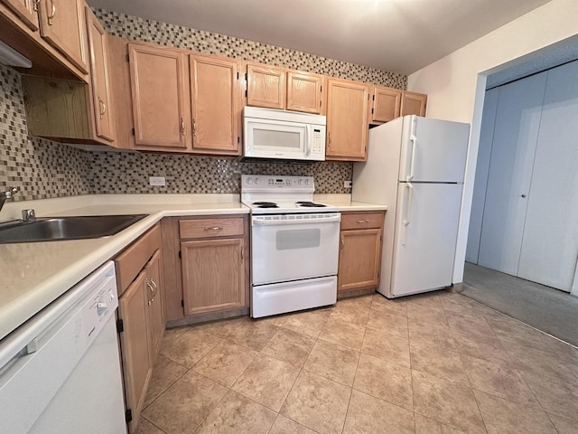 kitchen featuring light countertops, white appliances, backsplash, and a sink