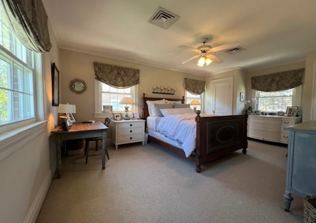 carpeted bedroom featuring crown molding, ceiling fan, and multiple windows