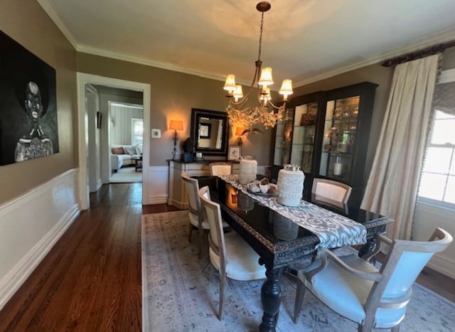 dining room with hardwood / wood-style flooring, crown molding, and an inviting chandelier