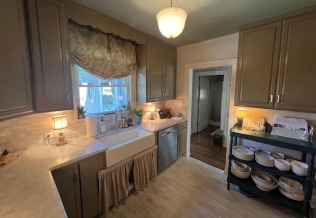 kitchen featuring sink, light hardwood / wood-style flooring, stainless steel dishwasher, pendant lighting, and decorative backsplash