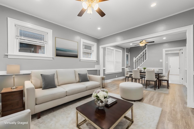 living room featuring crown molding, ceiling fan, and light wood-type flooring