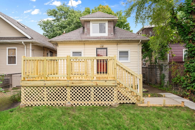 back of property featuring a wooden deck and a yard