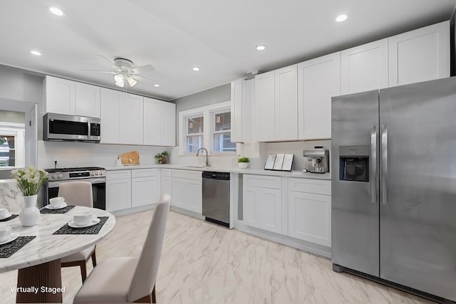 kitchen featuring white cabinetry, sink, stainless steel appliances, and a healthy amount of sunlight