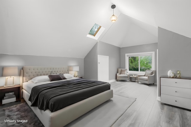 bedroom featuring lofted ceiling with skylight and hardwood / wood-style floors