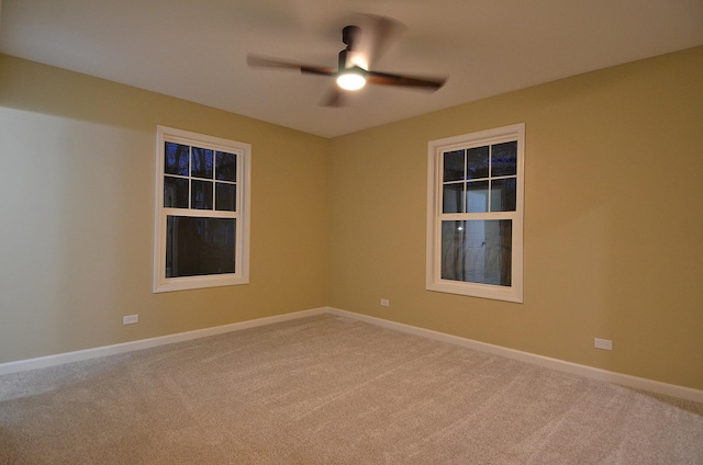 carpeted spare room featuring ceiling fan