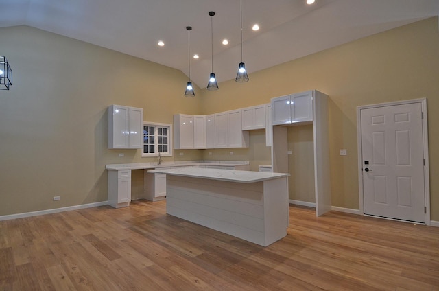 kitchen featuring a center island, pendant lighting, white cabinets, and high vaulted ceiling