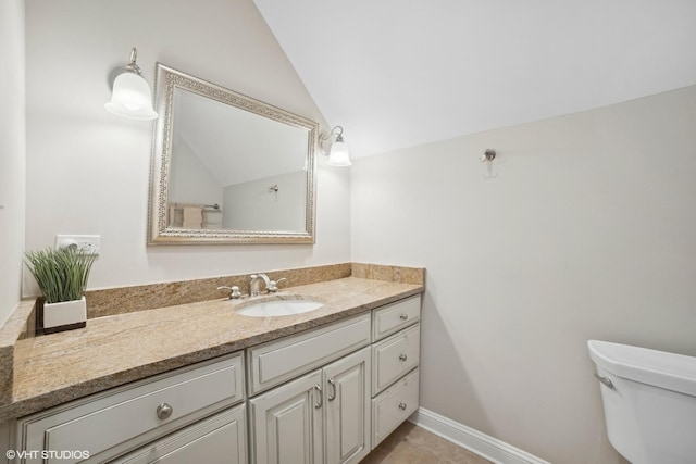 bathroom featuring lofted ceiling, toilet, and vanity