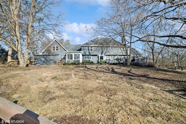 back of house featuring a yard and a sunroom