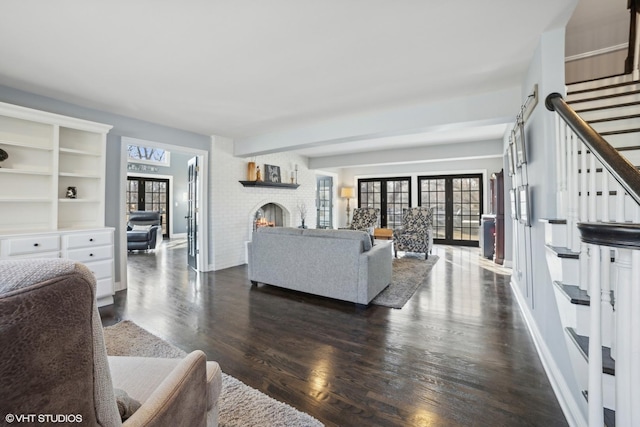 living room with dark hardwood / wood-style floors, a fireplace, and french doors