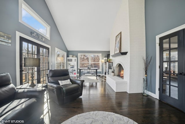 living room with dark wood-type flooring, a fireplace, high vaulted ceiling, and french doors