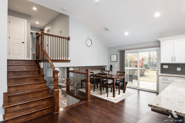 dining area featuring high vaulted ceiling and dark hardwood / wood-style floors