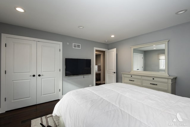 bedroom with dark wood-type flooring and a closet