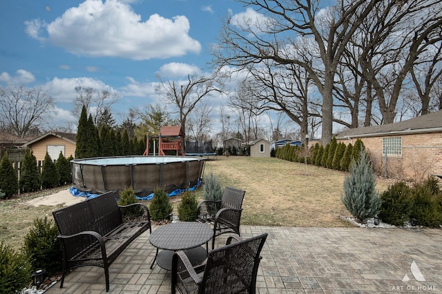 view of patio featuring a storage unit and a playground