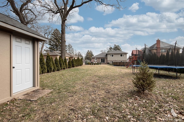 view of yard featuring a playground and a trampoline