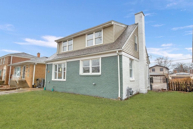 rear view of property featuring a lawn