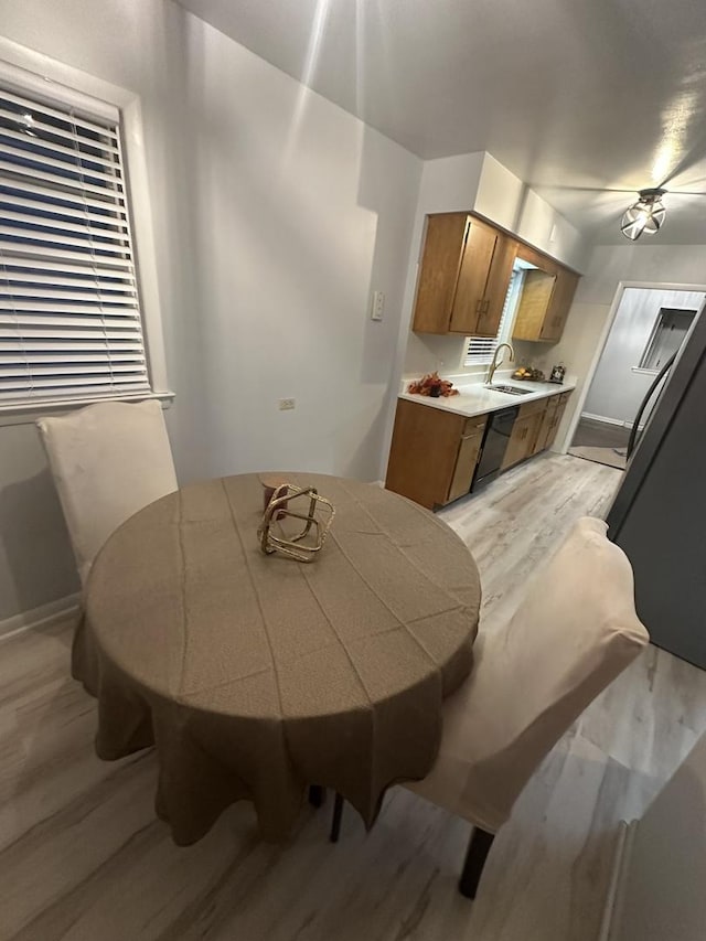 dining area with sink and light wood-type flooring