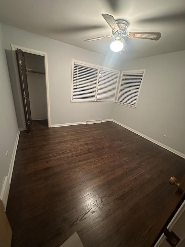 unfurnished bedroom featuring ceiling fan, dark hardwood / wood-style flooring, and a closet