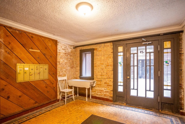 entryway with crown molding and a textured ceiling