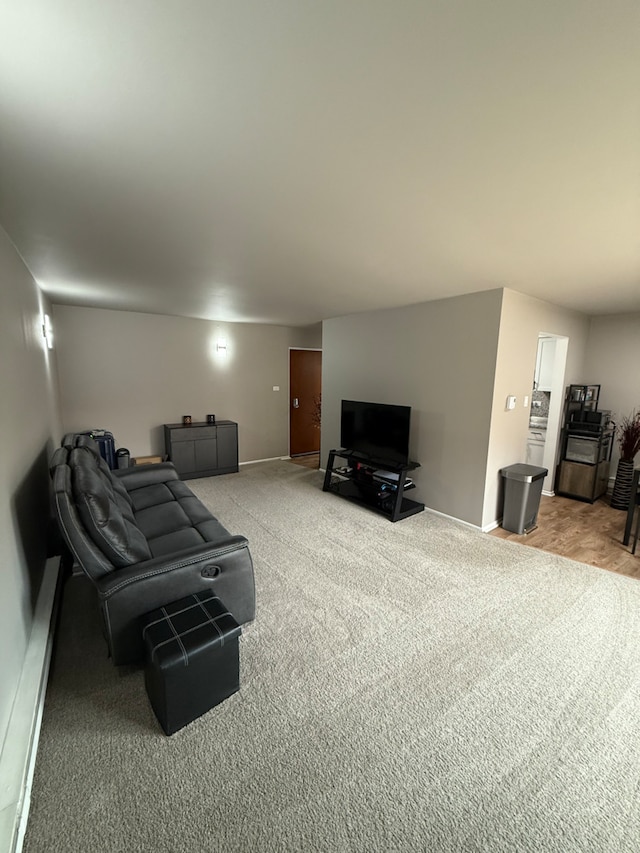 carpeted living room featuring a baseboard heating unit