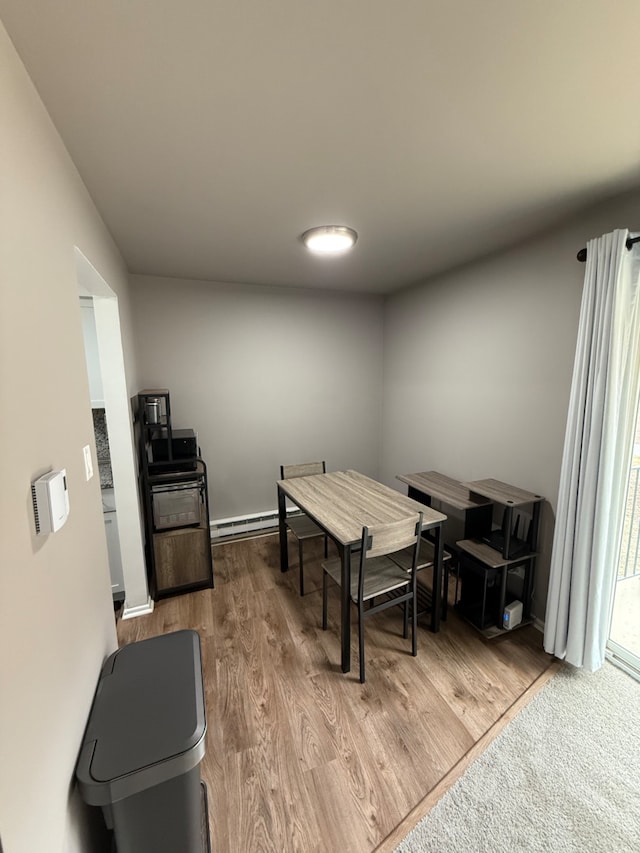 dining room featuring baseboard heating and wood-type flooring