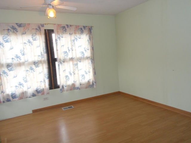 empty room with ceiling fan and hardwood / wood-style floors