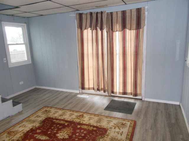 empty room with hardwood / wood-style flooring and a drop ceiling