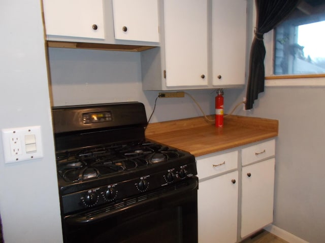 kitchen featuring black range with gas cooktop and white cabinetry