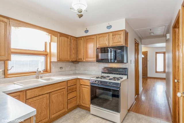 kitchen featuring sink, decorative backsplash, and gas range gas stove