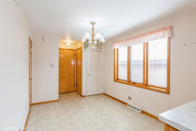 unfurnished room featuring a notable chandelier