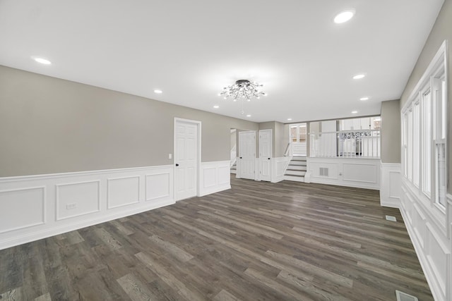 unfurnished living room with dark hardwood / wood-style flooring and a wealth of natural light